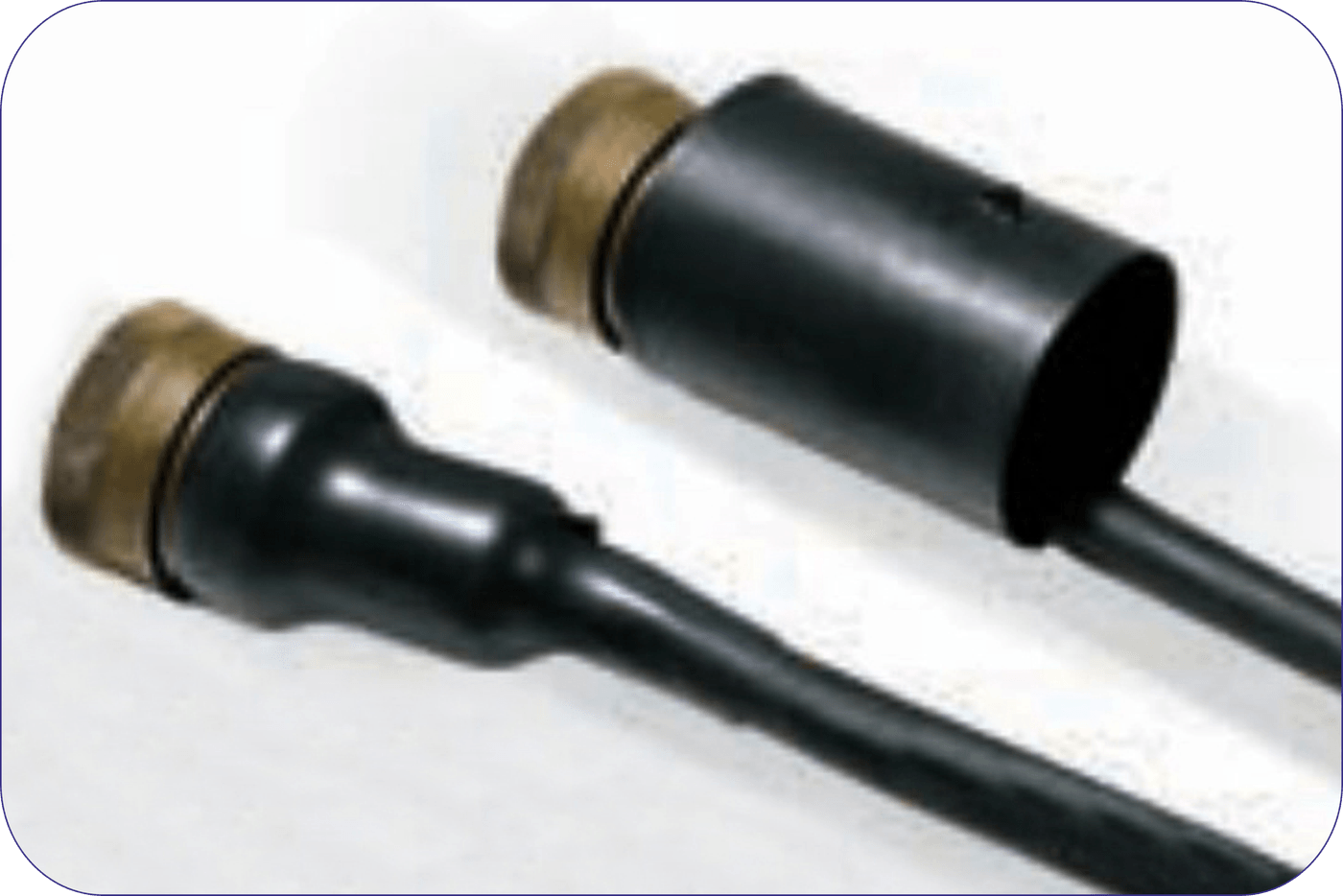 Two black straight boots on brass connector shells, one still cylindrical as supplied and one recovered down onto the cable behind it